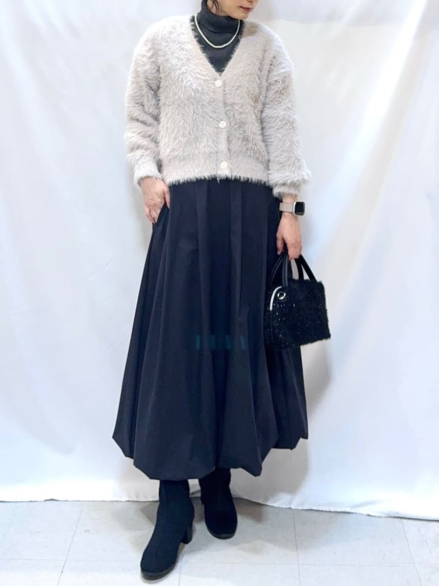 グレー系のカーディガン/ボレロ、グレー系のニット/セーター、ブラック系のスカートを着用したレディースの冬コーディネートの5枚目の写真