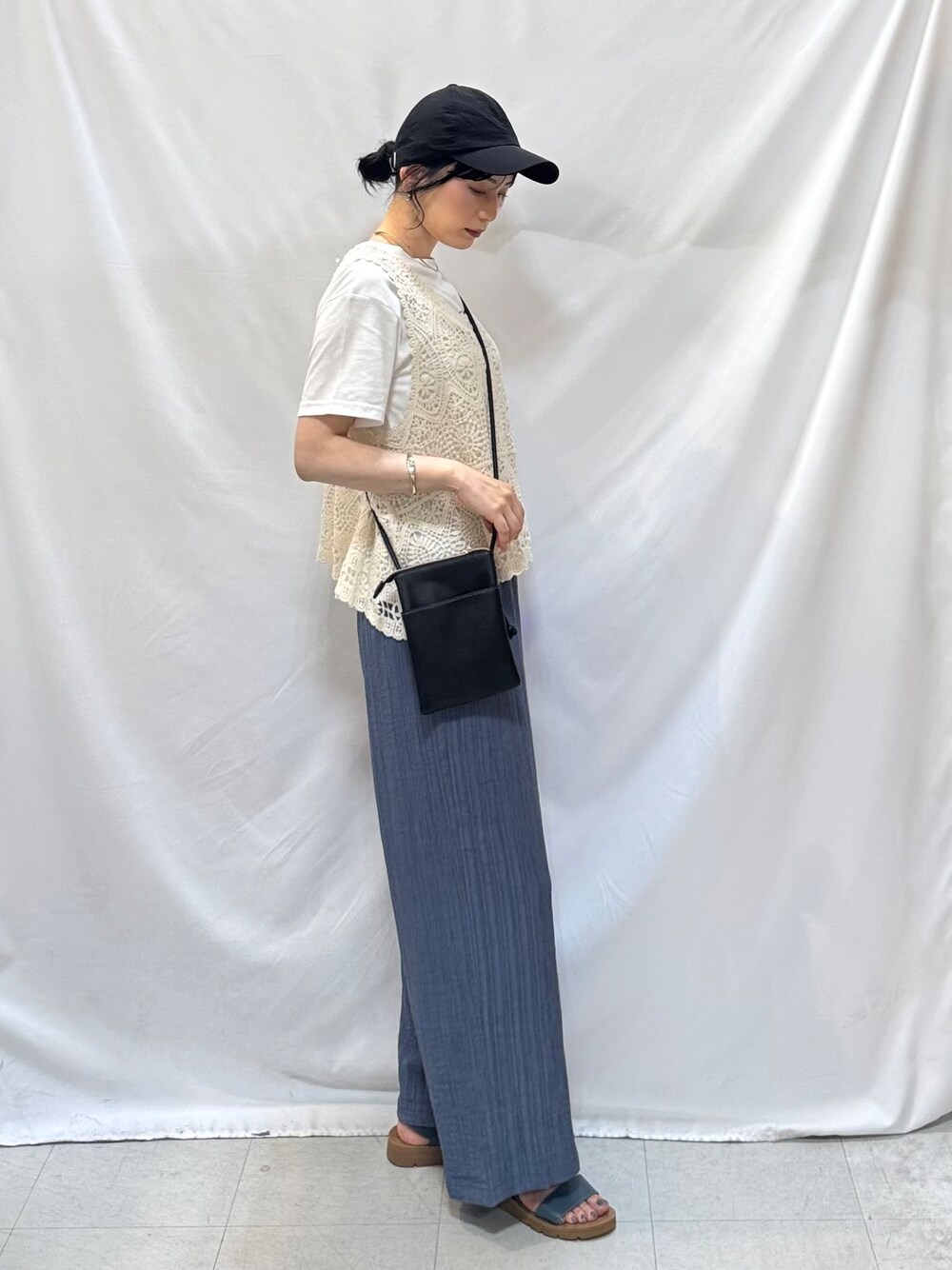 ブルー系のその他パンツ、ブルー系のサンダル、ブラック系のショルダーバッグを着用したレディースの夏コーディネートの4枚目の写真