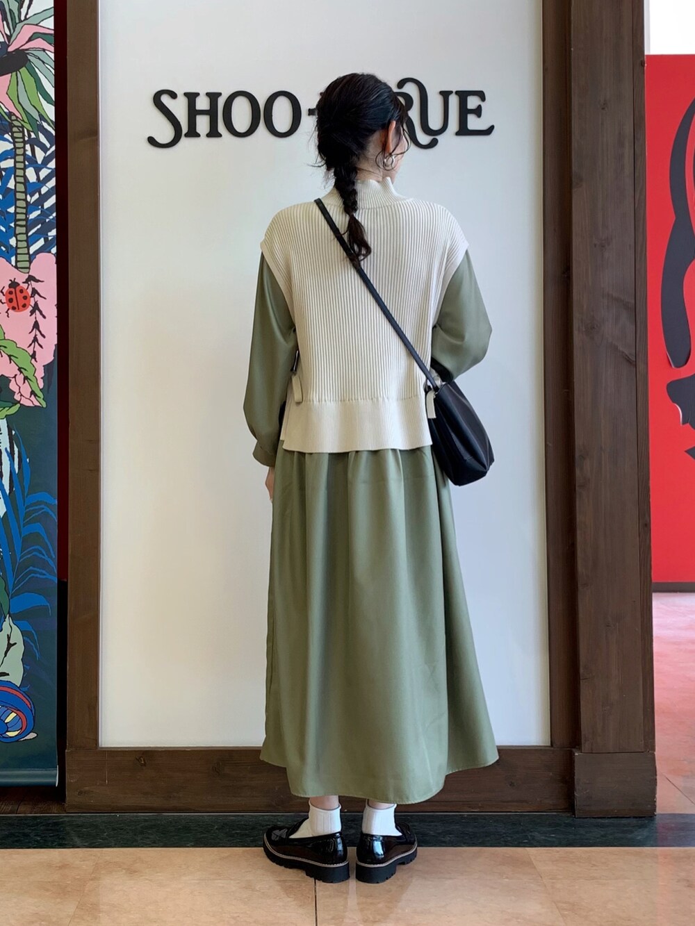 グリーン系のワンピース、ブラック系のショルダーバッグ、ブラック系のその他シューズを着用したレディースの冬コーディネートの3枚目の写真