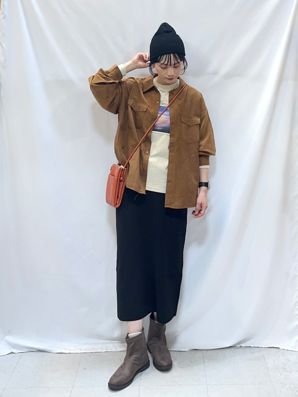 イエロー系のシャツ/ブラウス、ベージュ系のTシャツ/カットソー、ブラック系のスカートを着用したレディースの秋コーディネートの4枚目の写真