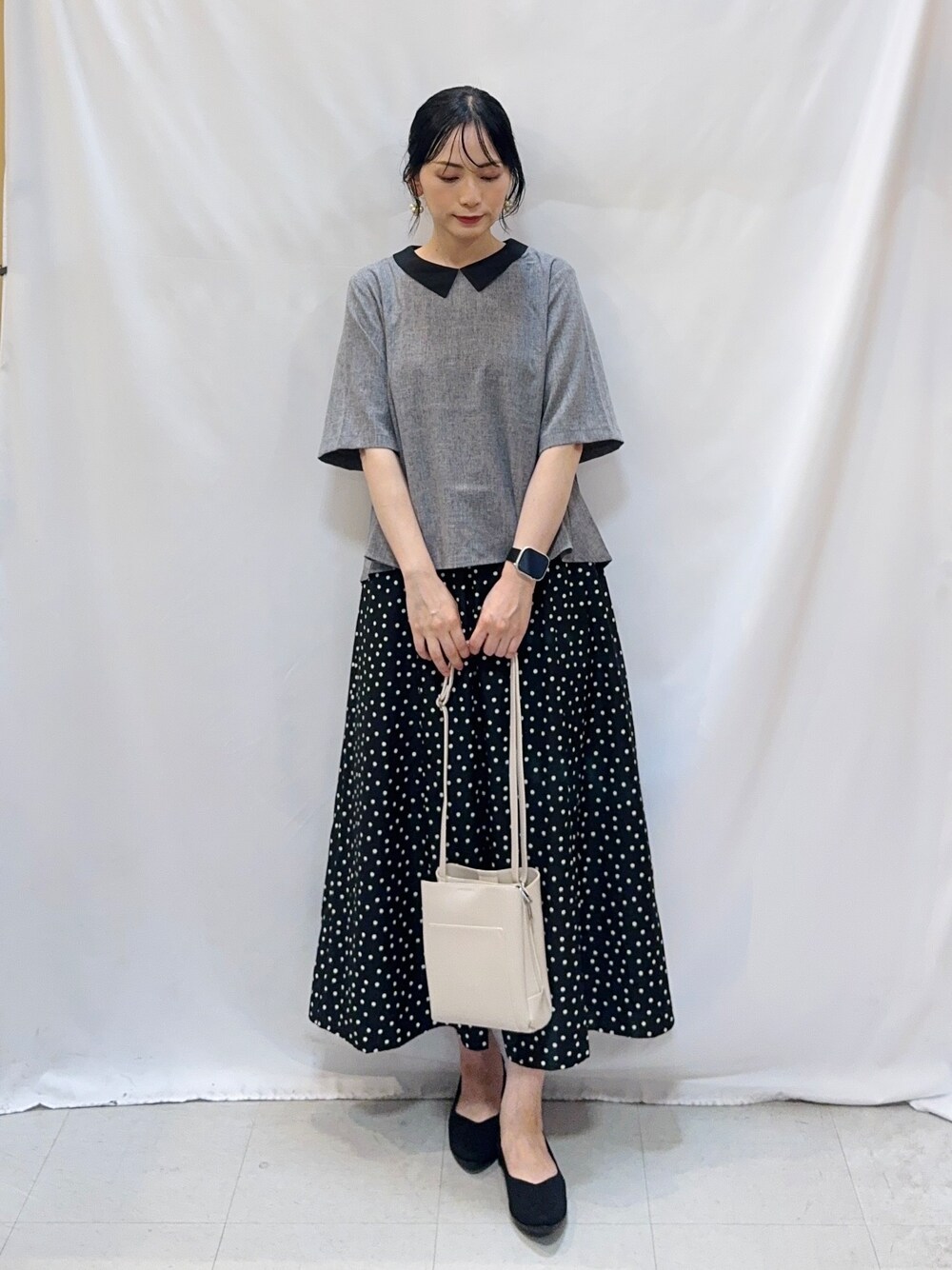 グレー系のシャツ/ブラウス、ブラック系のスカート、ブラック系のパンプスを着用したレディースの夏コーディネートの3枚目の写真