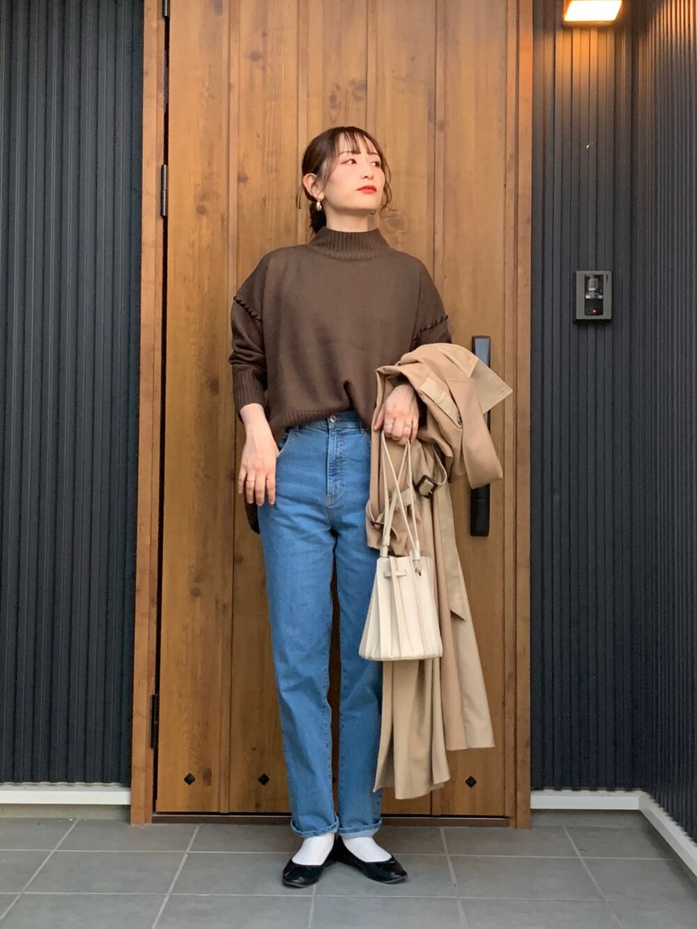 ブラウン系のニット/セーター、ブルー系のデニムパンツを着用したレディースの秋コーディネートの2枚目の写真