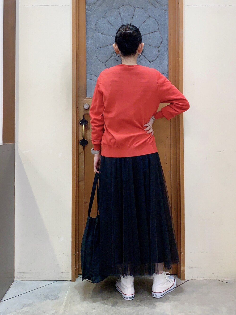 ブラック系のTシャツ/カットソー、レッド系のカーディガン/ボレロ、ブラック系のスカートを着用したレディースの春コーディネートの4枚目の写真