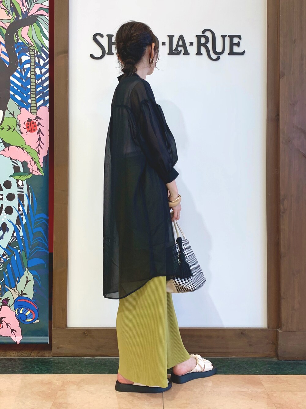 ホワイト系のタンクトップ、ブラック系のワンピース、グリーン系のその他パンツを着用したレディースの春コーディネートの2枚目の写真