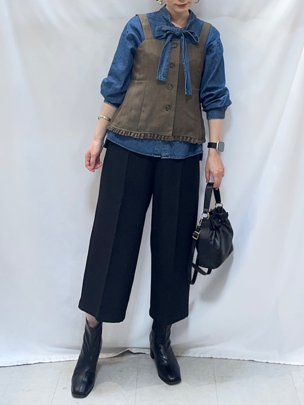 ブルー系のシャツ/ブラウス、ブラック系のその他パンツ、ブラック系のブーツを着用したレディースの秋コーディネートの5枚目の写真