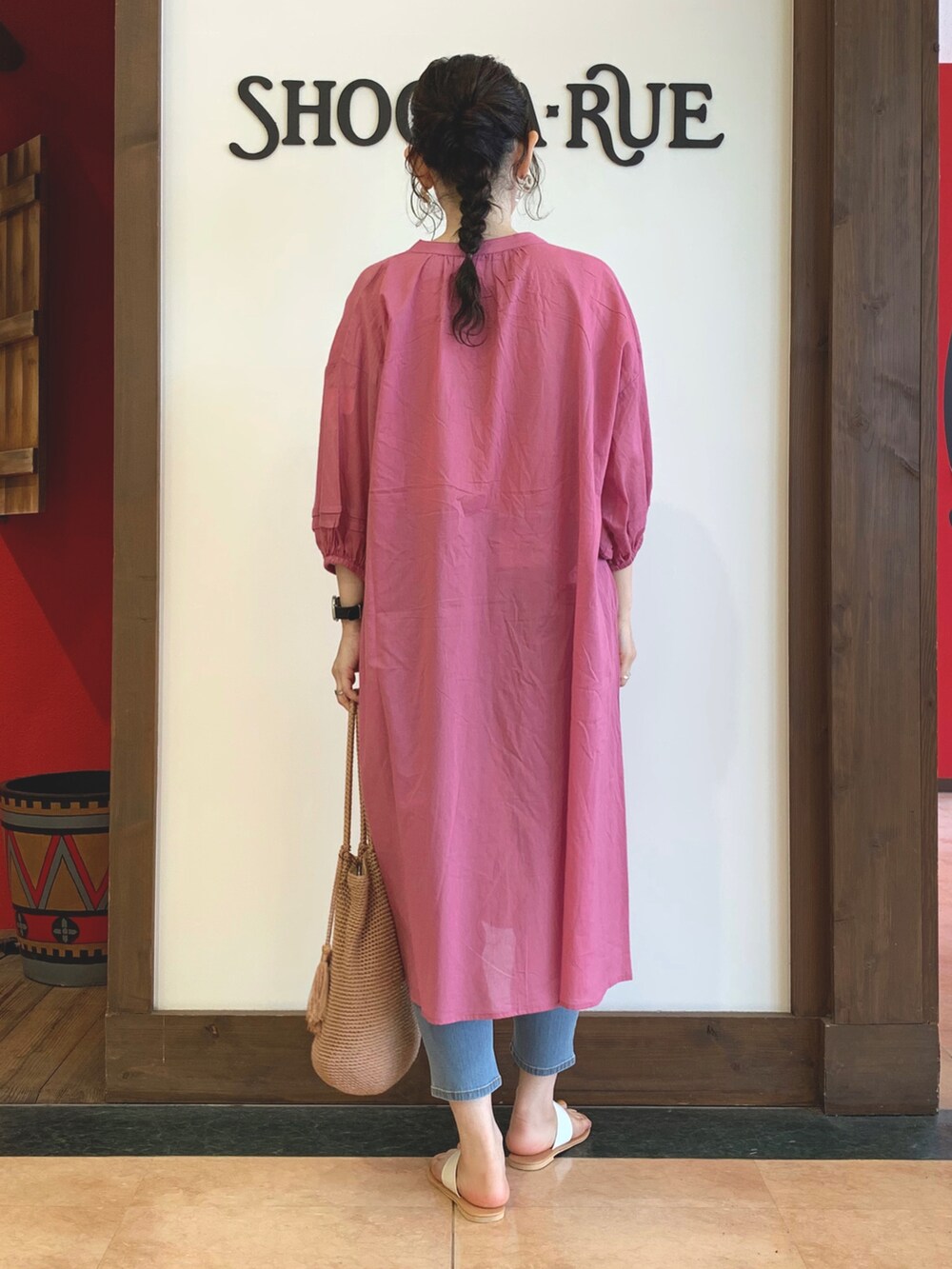 ピンク系のワンピース、オレンジ系のトートバッグ、ホワイト系のサンダルを着用したレディースの春コーディネートの3枚目の写真