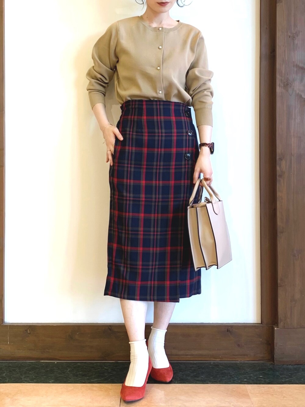 ベージュ系のカーディガン/ボレロ、ブルー系のスカート、グレー系のショルダーバッグを着用したレディースの秋コーディネートの2枚目の写真