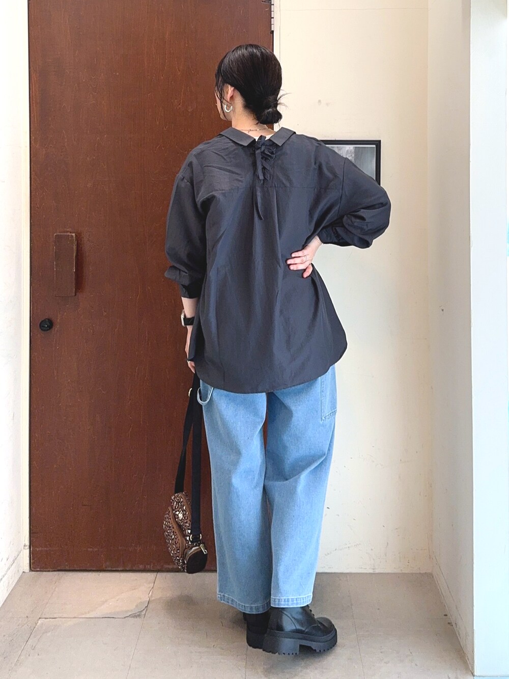 ホワイト系のTシャツ/カットソー、グレー系のシャツ/ブラウス、ブルー系のデニムパンツを着用したレディースの秋コーディネートの4枚目の写真