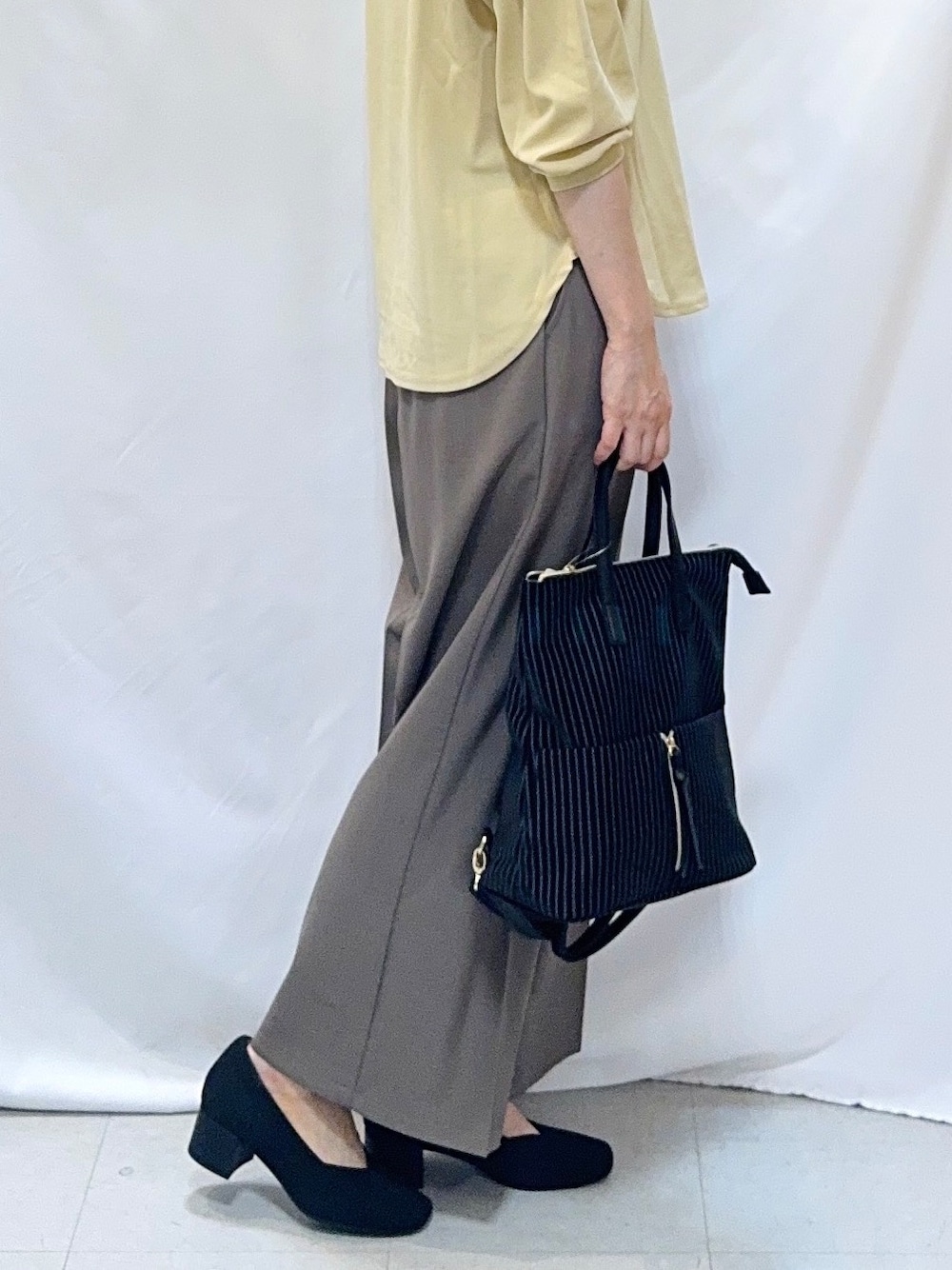 ブラウン系のその他パンツ、ブラック系のパンプス、ブラック系のバックパック/リュックを着用したレディースの秋コーディネートの6枚目の写真