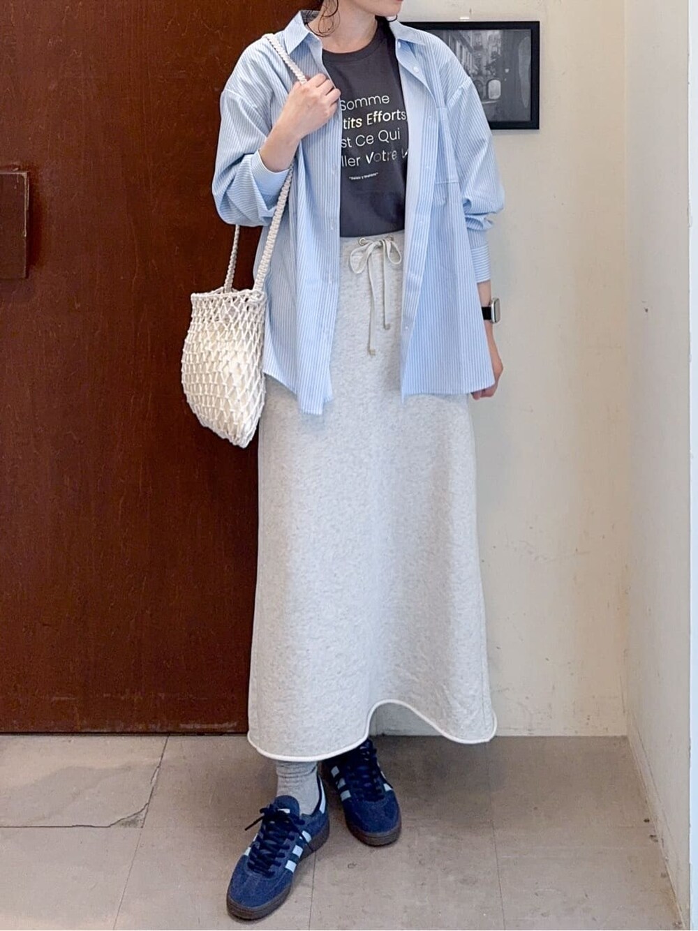 ブルー系のシャツ/ブラウス、グレー系のスカート、ホワイト系のショルダーバッグを着用したレディースの春コーディネートの5枚目の写真