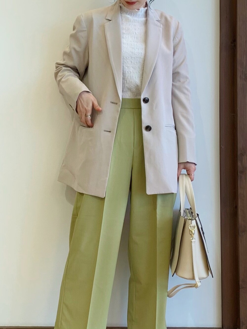 イエロー系のその他パンツ、グレー系のパンプス、ベージュ系のテーラードジャケットを着用したレディースの冬コーディネートの2枚目の写真