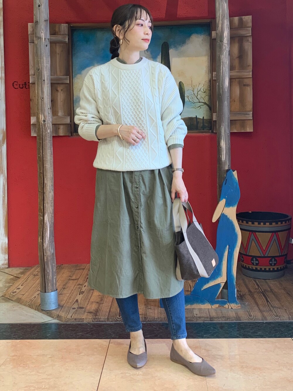 ホワイト系のニット/セーター、グリーン系のワンピース、ブラウン系のトートバッグを着用したレディースの秋コーディネートの3枚目の写真