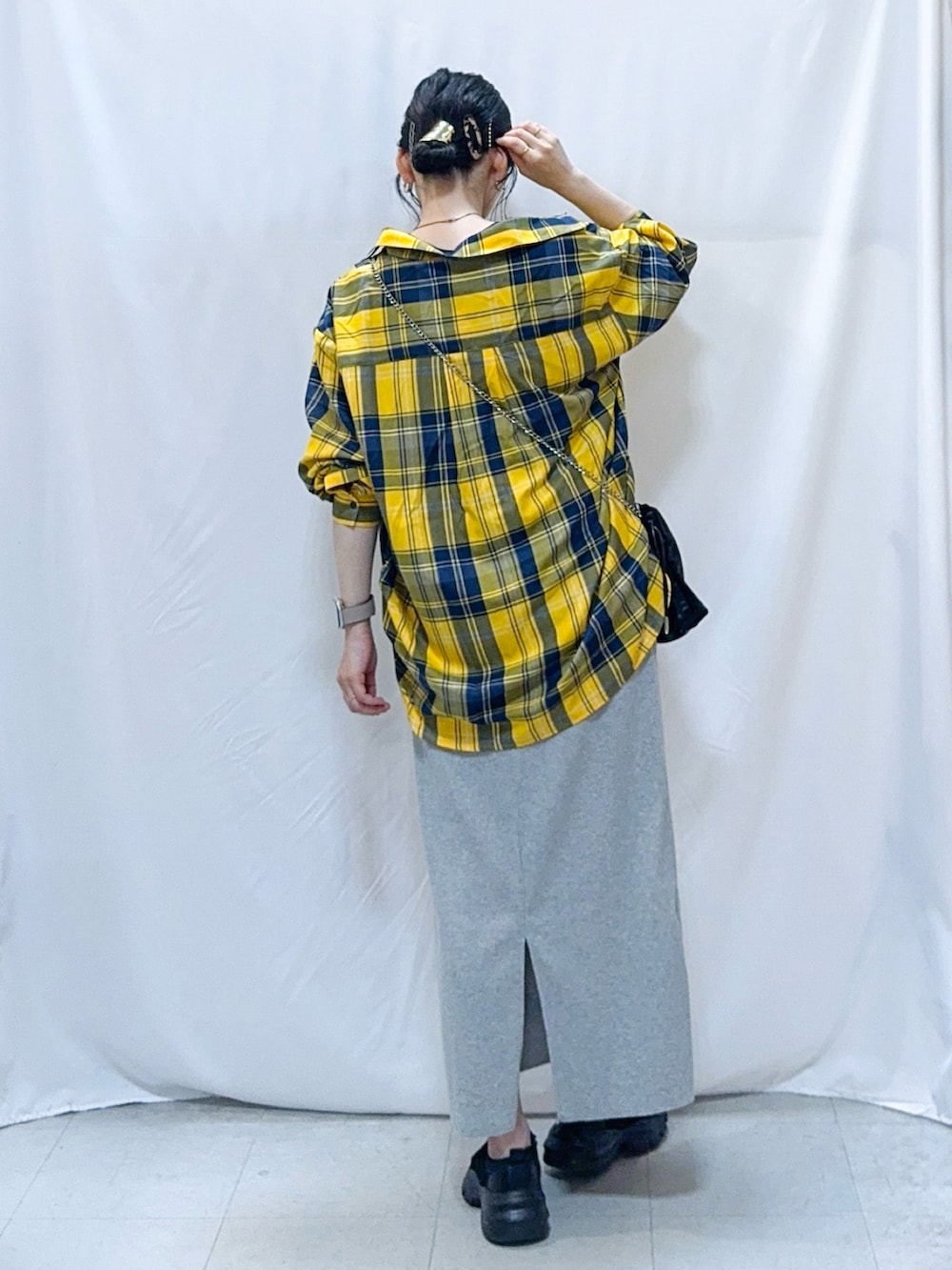 イエロー系のシャツ/ブラウス、ブルー系のTシャツ/カットソー、グレー系のスカートを着用したレディースの秋コーディネートの4枚目の写真