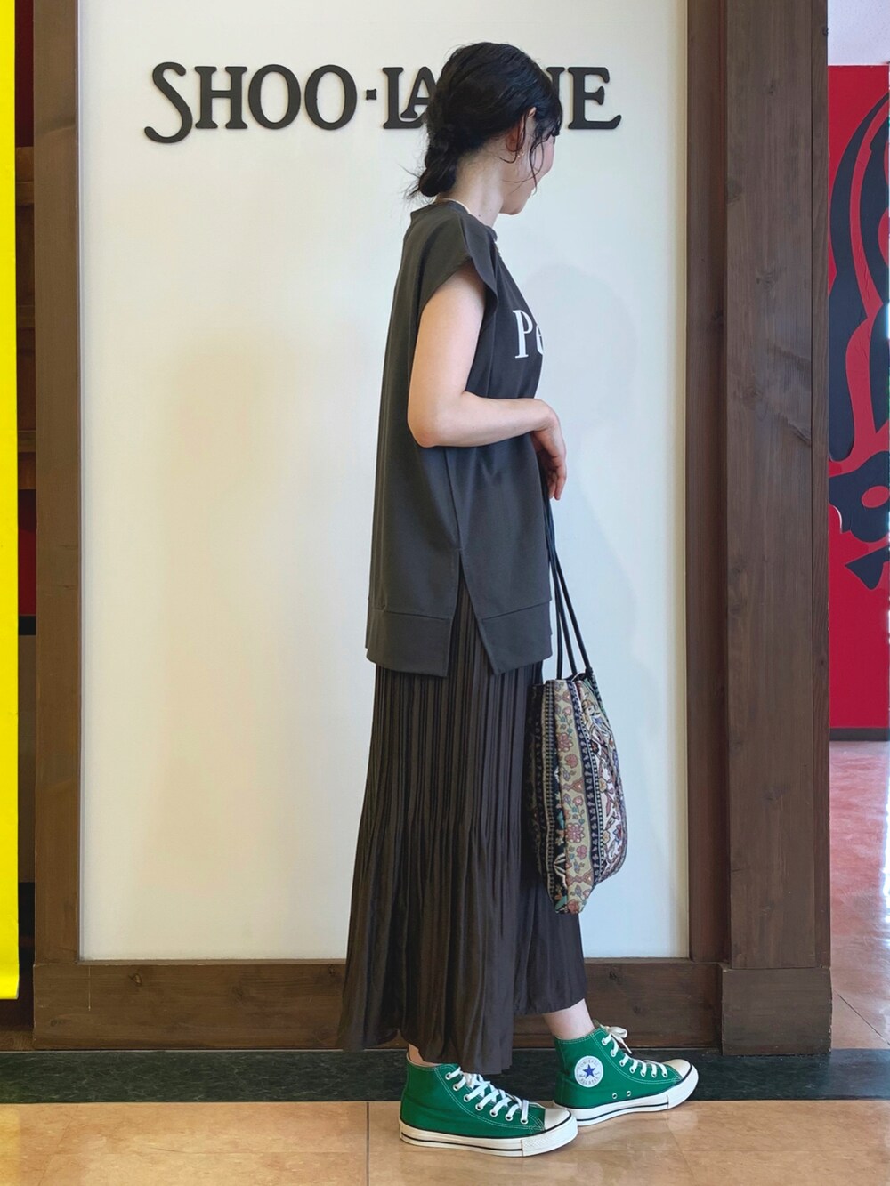 グレー系のTシャツ/カットソー、ブラウン系のスカート、ブラック系のトートバッグを着用したレディースの夏コーディネートの2枚目の写真