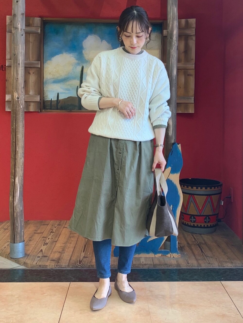 ホワイト系のニット/セーター、グリーン系のワンピース、ブラウン系のトートバッグを着用したレディースの秋コーディネートの2枚目の写真