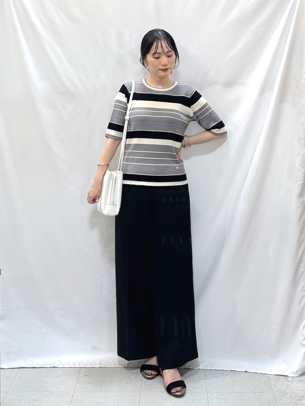 グレー系のニット/セーター、ブラック系のその他パンツ、ブラック系のサンダルを着用したレディースの夏コーディネートの2枚目の写真