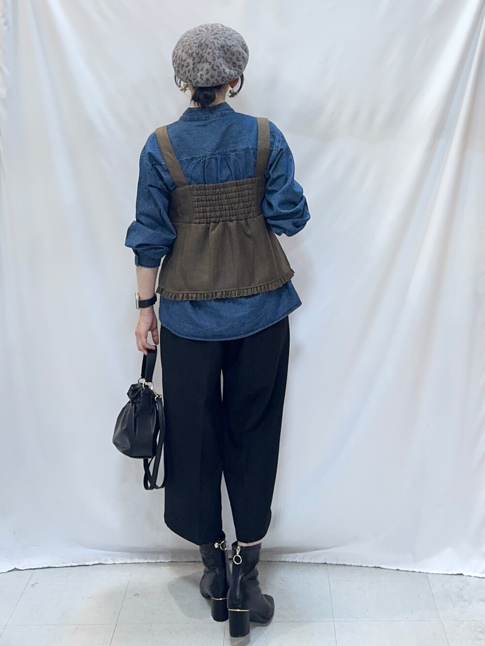 ブルー系のシャツ/ブラウス、ブラック系のその他パンツ、ブラック系のブーツを着用したレディースの秋コーディネートの3枚目の写真