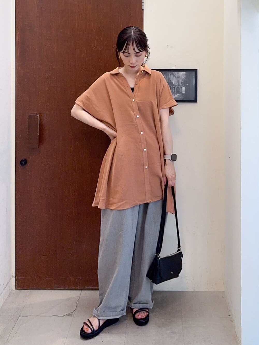 オレンジ系のチュニック、ブラック系のタンクトップ、グレー系のその他パンツを着用したレディースの夏コーディネートの2枚目の写真