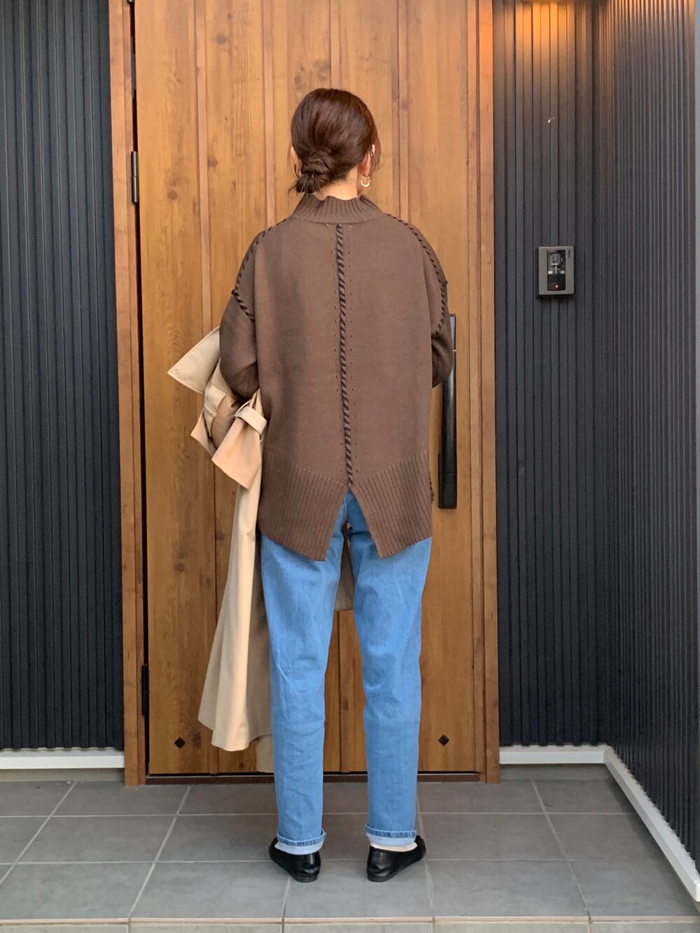 ブラウン系のニット/セーター、ブルー系のデニムパンツを着用したレディースの秋コーディネートの5枚目の写真