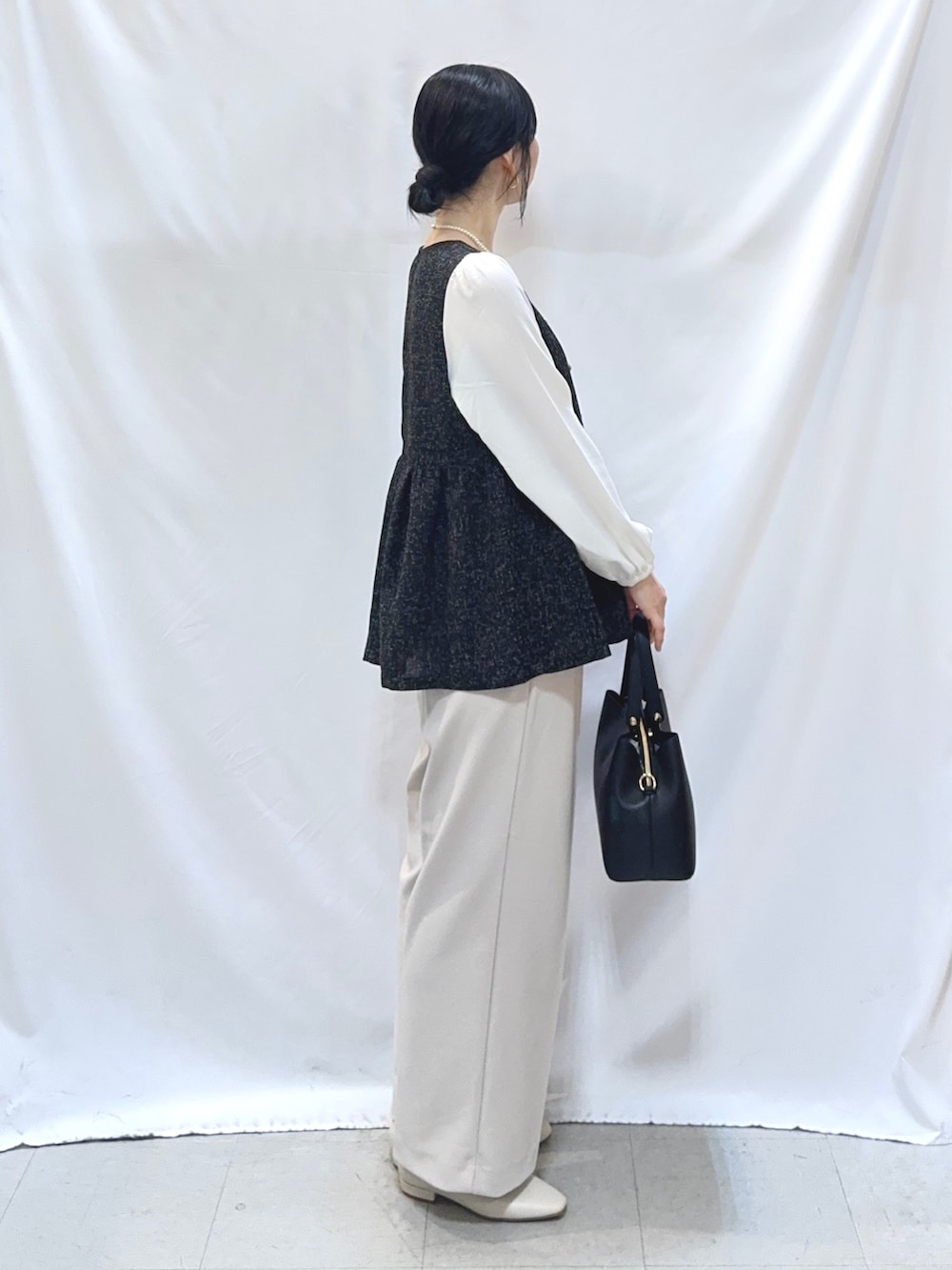 ブラック系のシャツ/ブラウス、ベージュ系のその他パンツ、ホワイト系のパンプスを着用したレディースの冬コーディネートの3枚目の写真