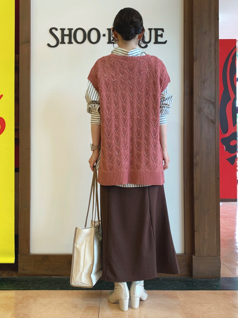 グレー系のシャツ/ブラウス、ピンク系のベスト、ブラウン系のスカートを着用したレディースの秋コーディネートの3枚目の写真