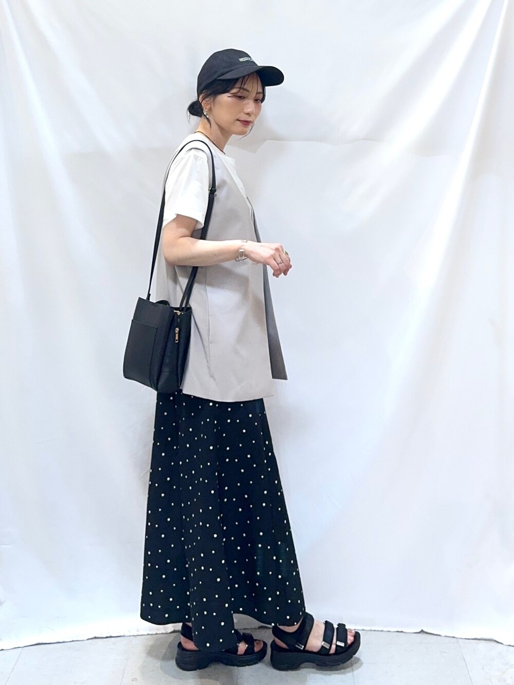 ベージュ系のベスト、ホワイト系のTシャツ/カットソー、ブラック系のスカートを着用したレディースの夏コーディネートの4枚目の写真
