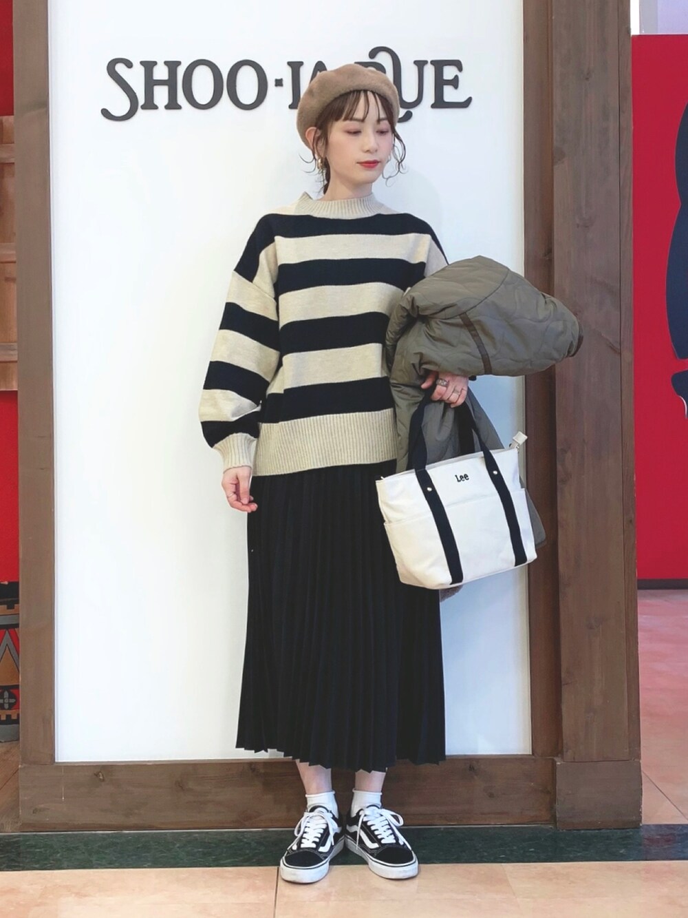 ブラウン系のその他アウター、ブラック系のニット/セーター、ブラック系のスカートを着用したレディースの冬コーディネートの2枚目の写真