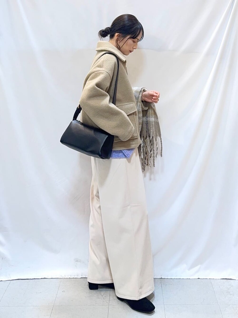 ベージュ系のブルゾン、ブルー系のニット/セーター、ホワイト系のその他パンツを着用したレディースの冬コーディネートの3枚目の写真