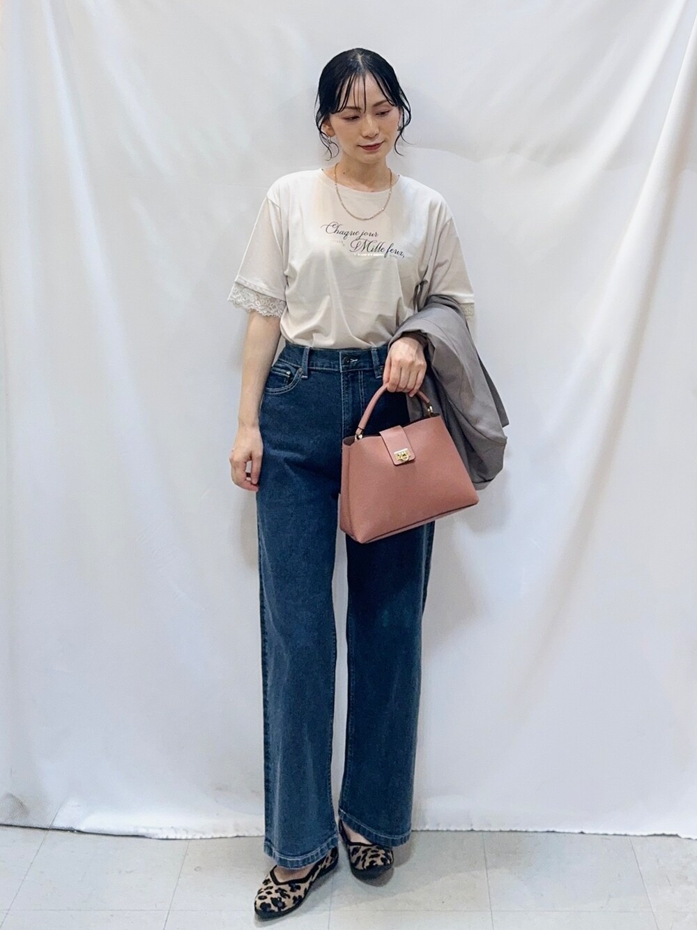 ブラウン系のテーラードジャケット、ベージュ系のTシャツ/カットソー、ブルー系のデニムパンツを着用したレディースの秋コーディネートの4枚目の写真