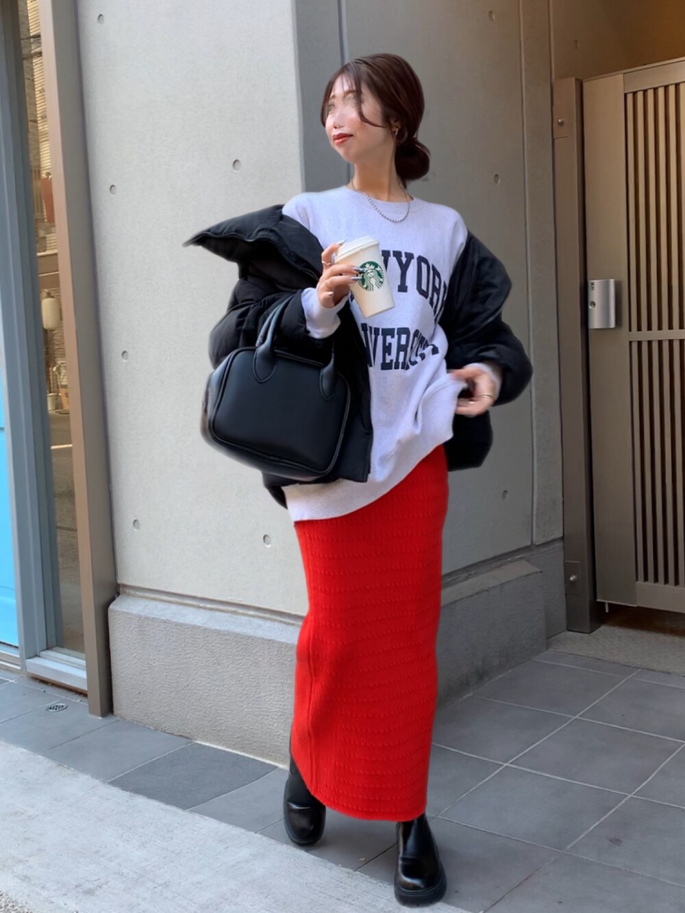 ブラック系のダウンジャケット/コート、レッド系のスカートを着用したレディースの冬コーディネートの2枚目の写真