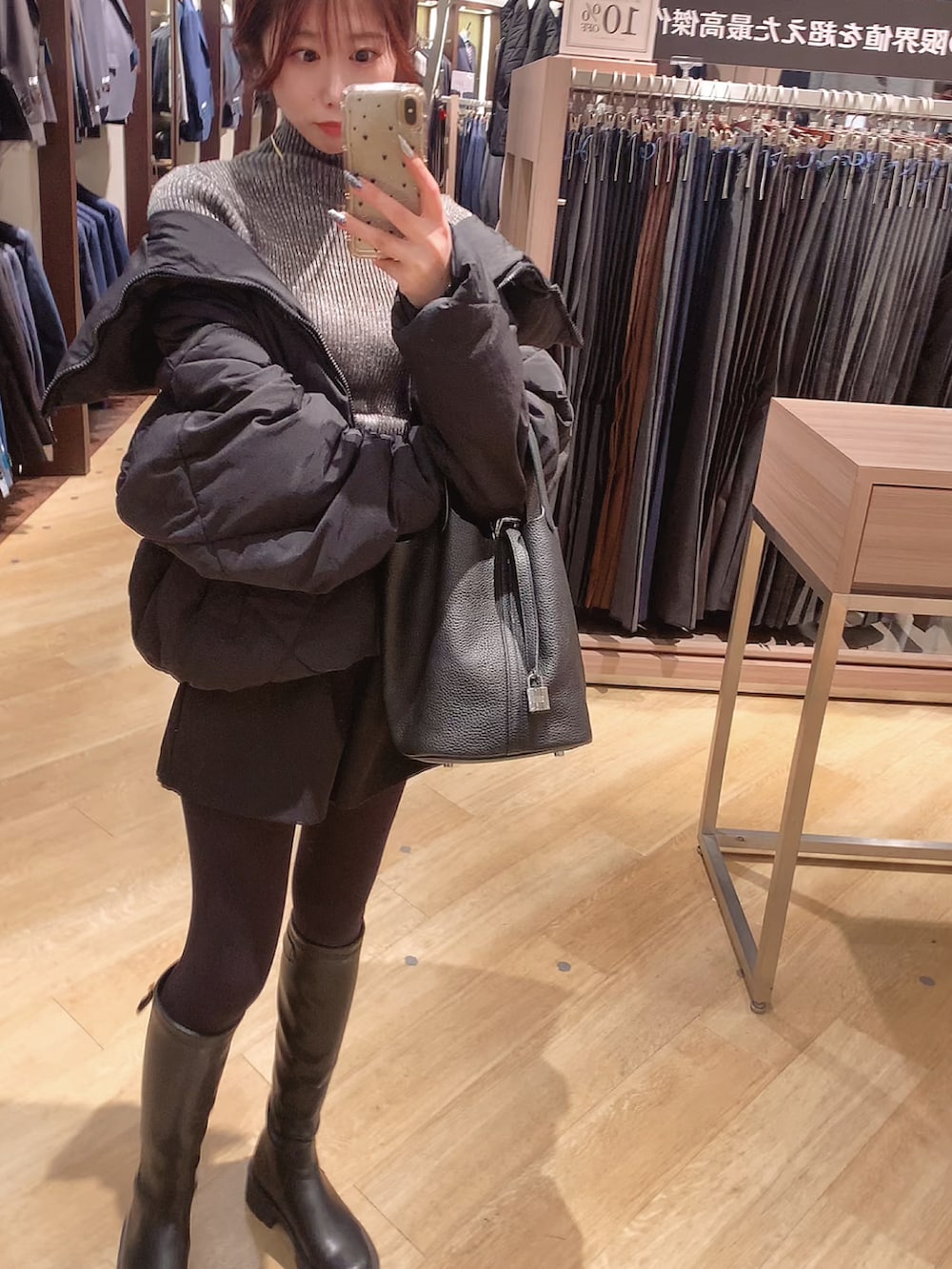 ブラック系のダウンジャケット/コート、ブラック系のブーツを着用したレディースの冬コーディネートの2枚目の写真