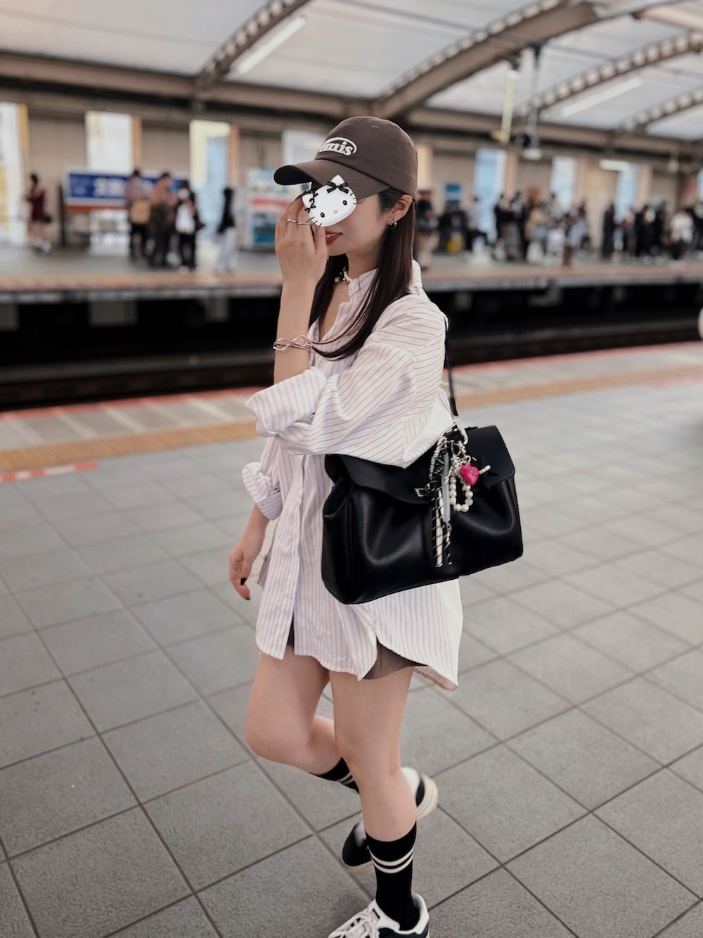 ホワイト系のシャツ/ブラウス、ブラック系のスニーカーを着用したレディースの春コーディネートの2枚目の写真