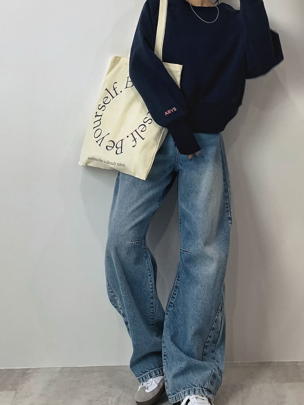 ブルー系のスウェット、ホワイト系のスニーカーを着用したレディースの秋コーディネートの2枚目の写真