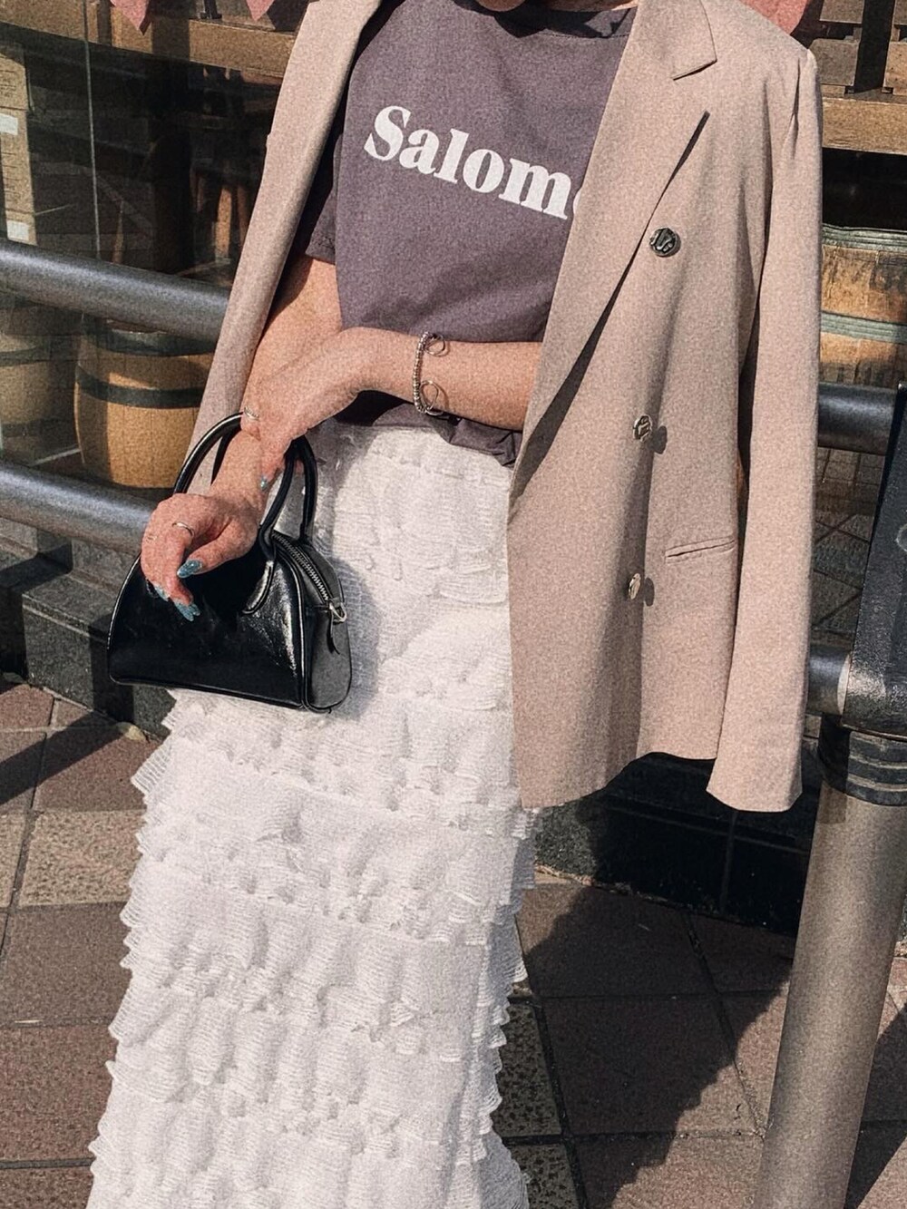 ホワイト系のスカート、グレー系のTシャツ/カットソーを着用したレディースの春コーディネートの3枚目の写真
