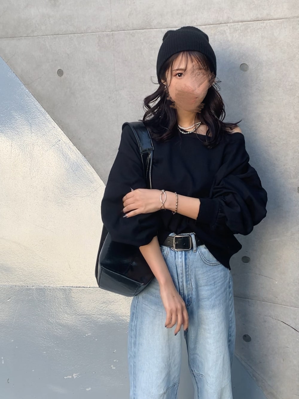 ブラック系のニット/セーター、ブルー系のデニムパンツ、ブラック系のニットキャップ/ビーニーを着用したレディースの秋コーディネートの2枚目の写真