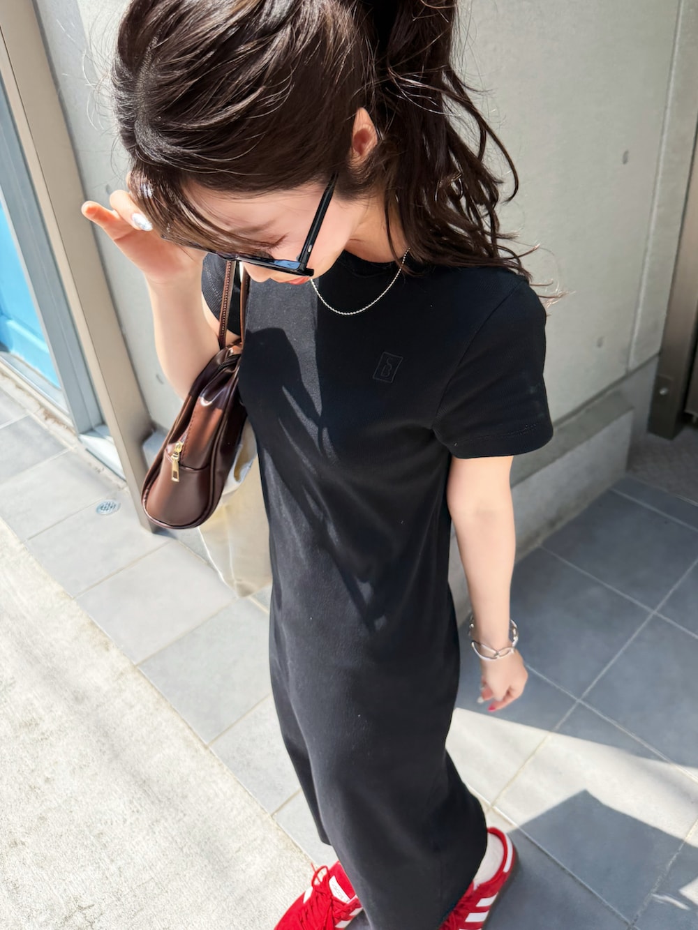 ブラック系のワンピースを着用したレディースの春コーディネートの2枚目の写真