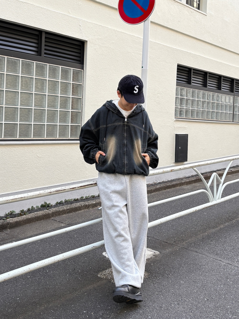 ブラック系のブルゾン、ホワイト系のTシャツ/カットソー、ブラック系のモカシン/デッキシューズを着用したメンズの春コーディネートの2枚目の写真