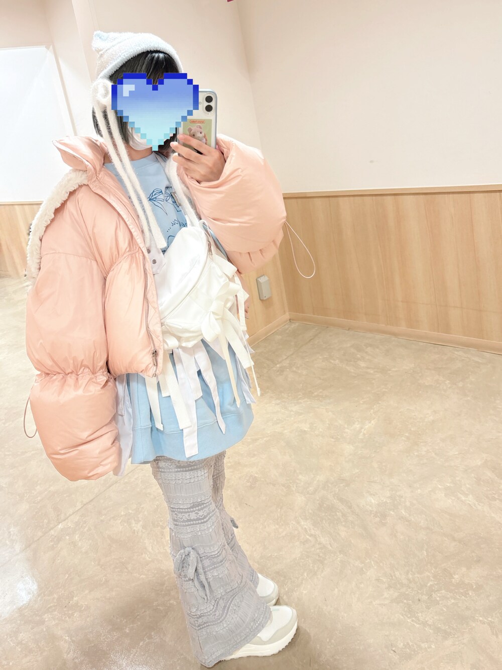 ピンク系のダウンジャケット/コート、ホワイト系のボディバッグ/ウエストポーチ、ブルー系のスウェットを着用したレディースの冬コーディネートの3枚目の写真