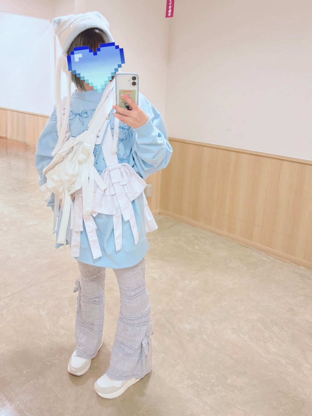 ピンク系のダウンジャケット/コート、ホワイト系のボディバッグ/ウエストポーチ、ブルー系のスウェットを着用したレディースの冬コーディネートの4枚目の写真