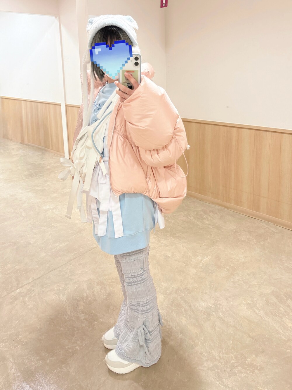 ピンク系のダウンジャケット/コート、ホワイト系のボディバッグ/ウエストポーチ、ブルー系のスウェットを着用したレディースの冬コーディネートの2枚目の写真