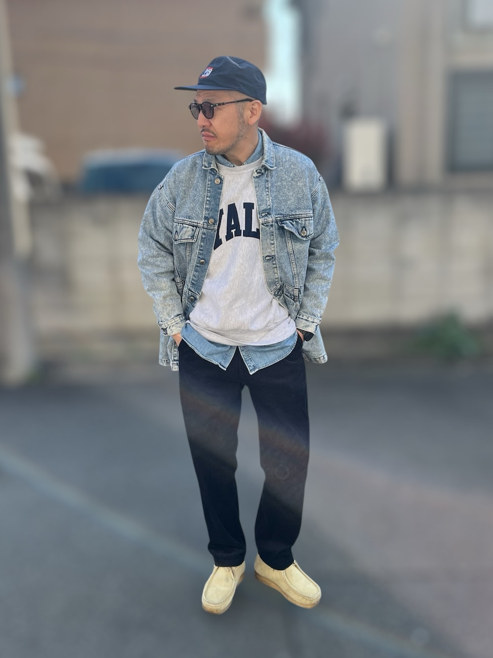 グレー系のスウェット、ブルー系のデニムジャケット、ベージュ系のブーツを着用したメンズの春コーディネートの2枚目の写真