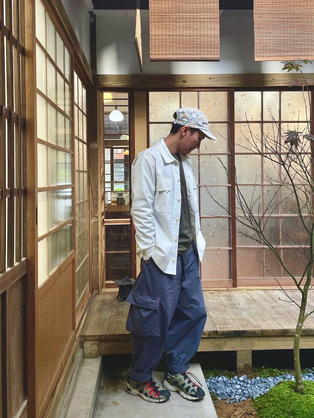 ブルー系のチノパンツ、ホワイト系のジャケット/アウター、グリーン系のシューズを着用したメンズの春コーディネートの4枚目の写真