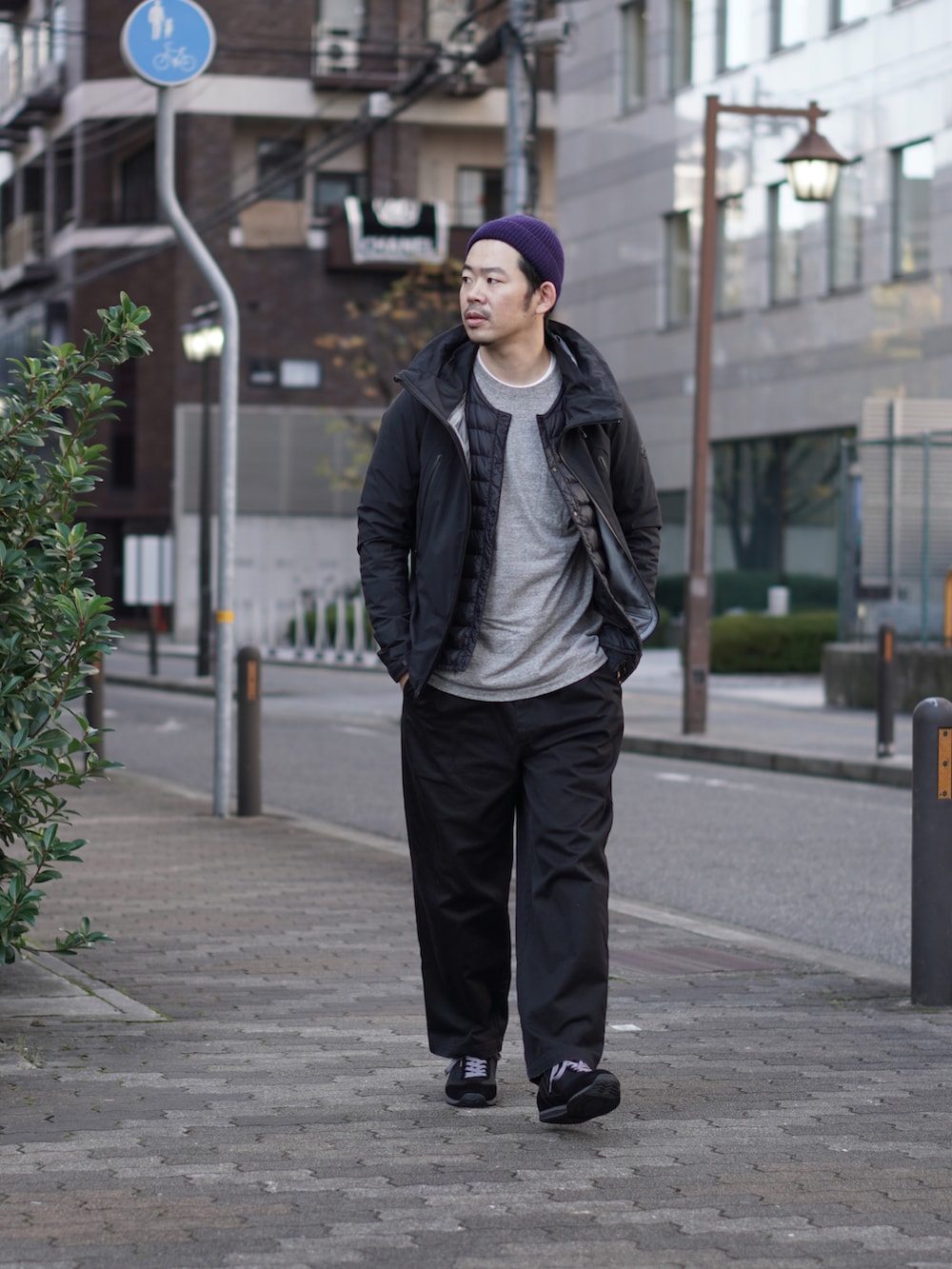 ブラック系のダウンジャケット/コート、グレー系のTシャツ/カットソー、ブラック系のチノパンツを着用したメンズの冬コーディネートの2枚目の写真