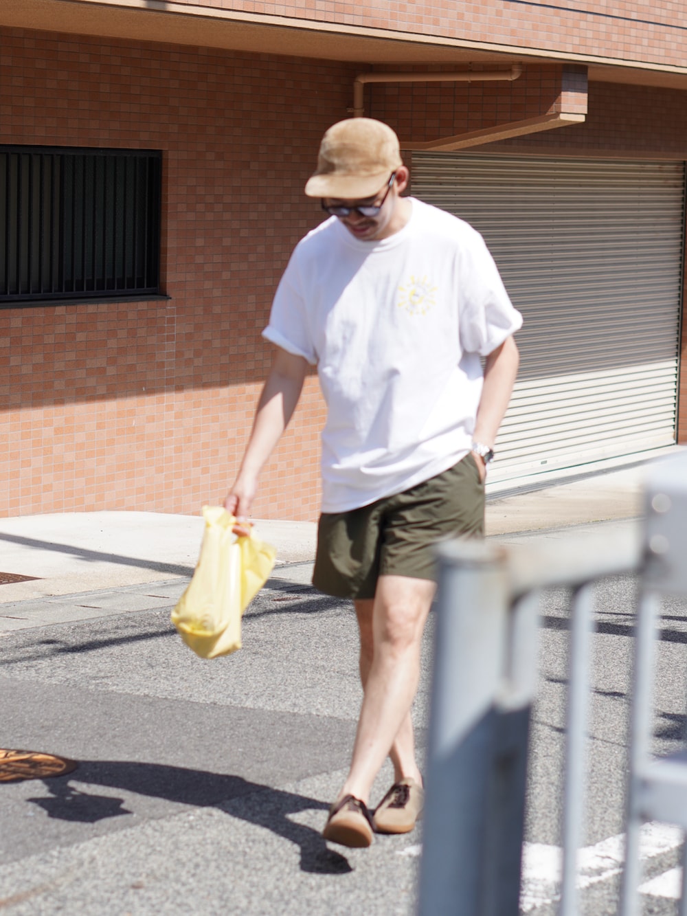 ホワイト系のTシャツ/カットソー、グリーン系のパンツ、ベージュ系のスニーカーを着用したメンズの夏コーディネートの2枚目の写真