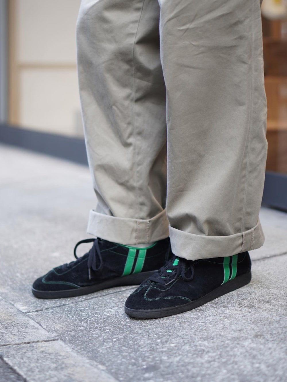 ブラック系のカーディガン/ボレロ、ホワイト系のTシャツ/カットソー、ベージュ系のチノパンツを着用したメンズの冬コーディネートの2枚目の写真