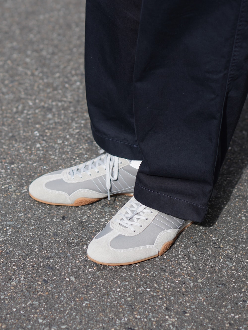 グレー系のTシャツ/カットソー、ブラック系のバックパック/リュック、グレー系のスニーカーを着用したメンズの夏コーディネートの2枚目の写真