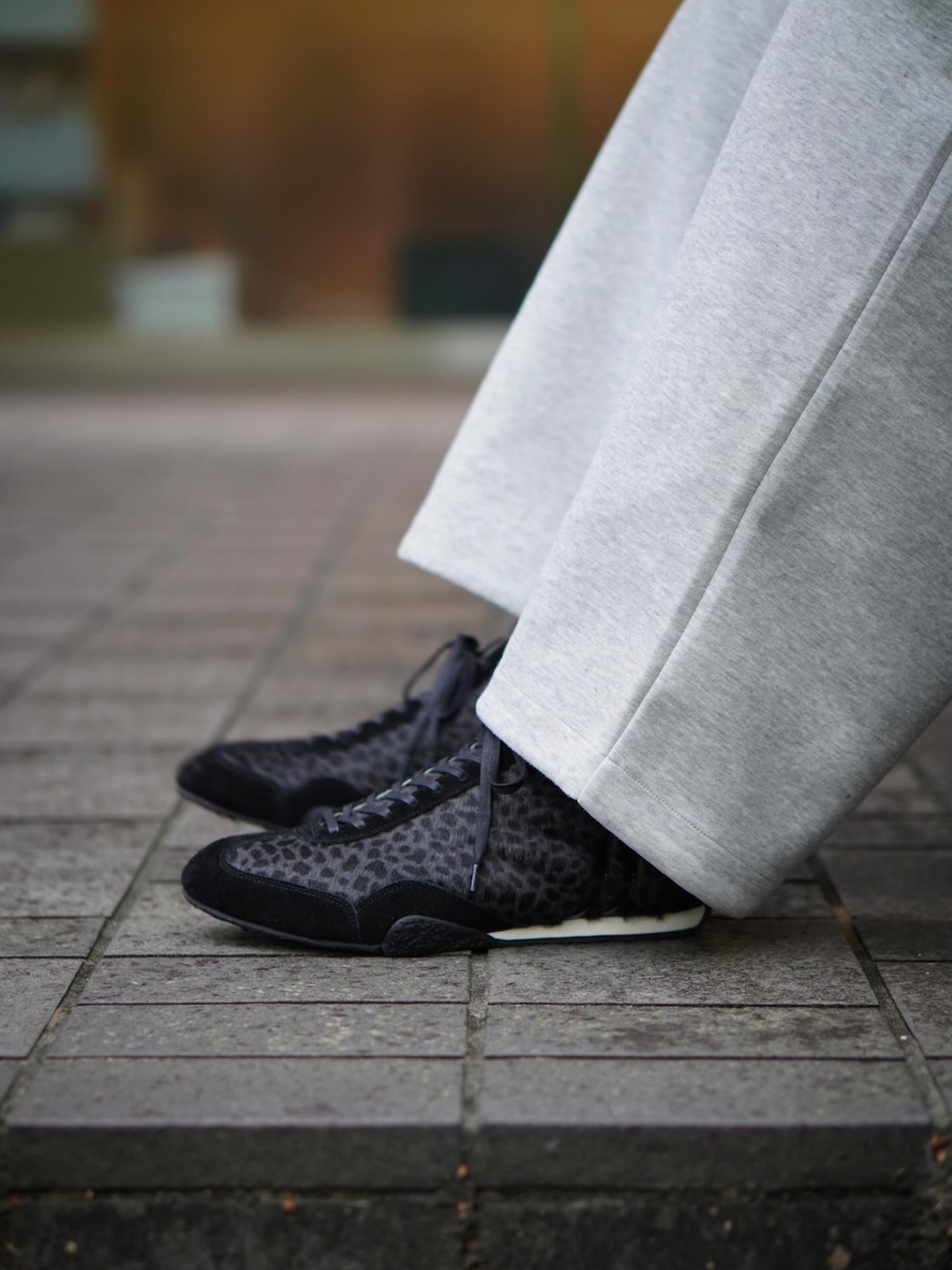 ブラック系のバックパック/リュック、ブラック系のニット/セーター、グレー系のスウェットパンツを着用したメンズの春コーディネートの2枚目の写真