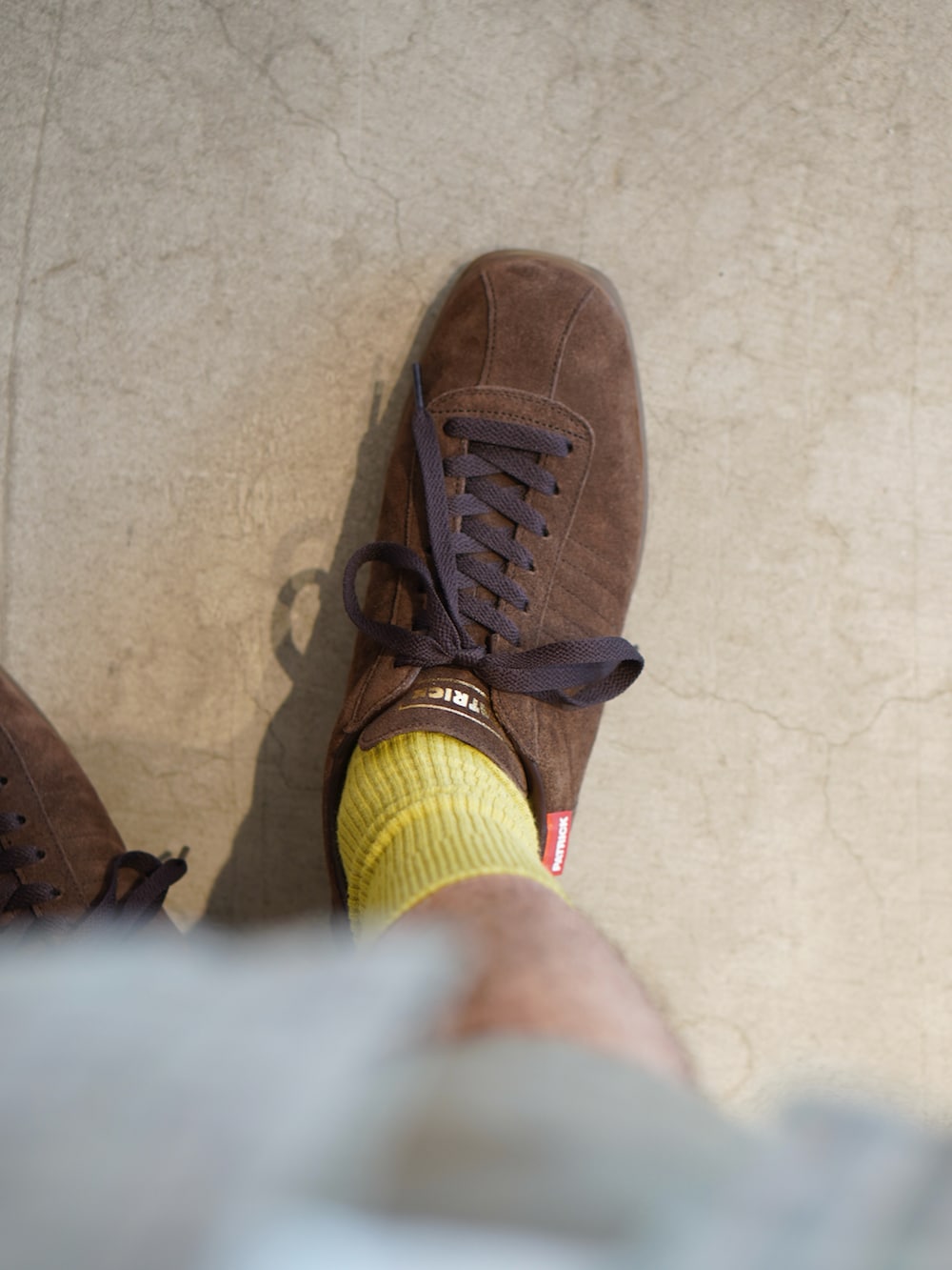 グリーン系のシャツ/ブラウス、ベージュ系のチノパンツ、ブラウン系のスニーカーを着用したメンズの秋コーディネートの3枚目の写真