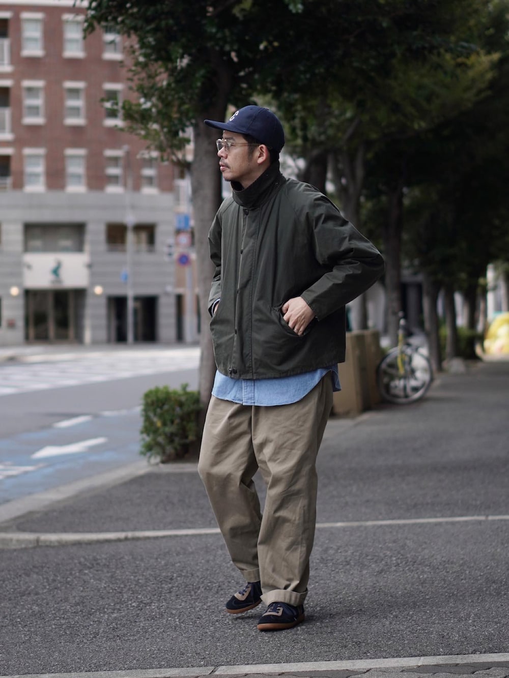 グリーン系のジャケット/アウター、ブルー系のシャツ/ブラウス、ベージュ系のチノパンツを着用したメンズの冬コーディネートの2枚目の写真