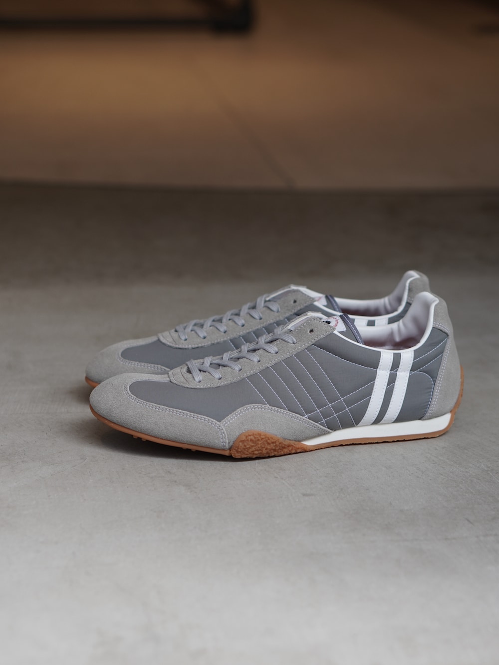 グレー系のTシャツ/カットソー、ブラック系のバックパック/リュック、グレー系のスニーカーを着用したメンズの夏コーディネートの3枚目の写真